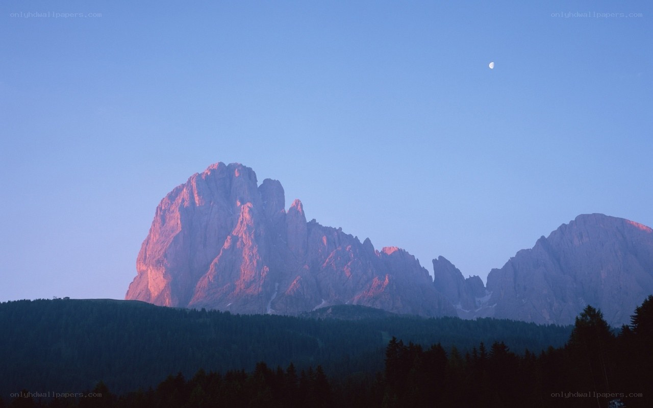 mountain peak at dusk with moon
