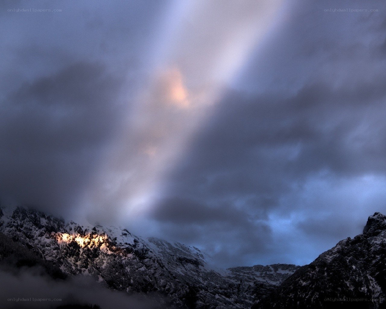 Mountain peak illuminated by light beam