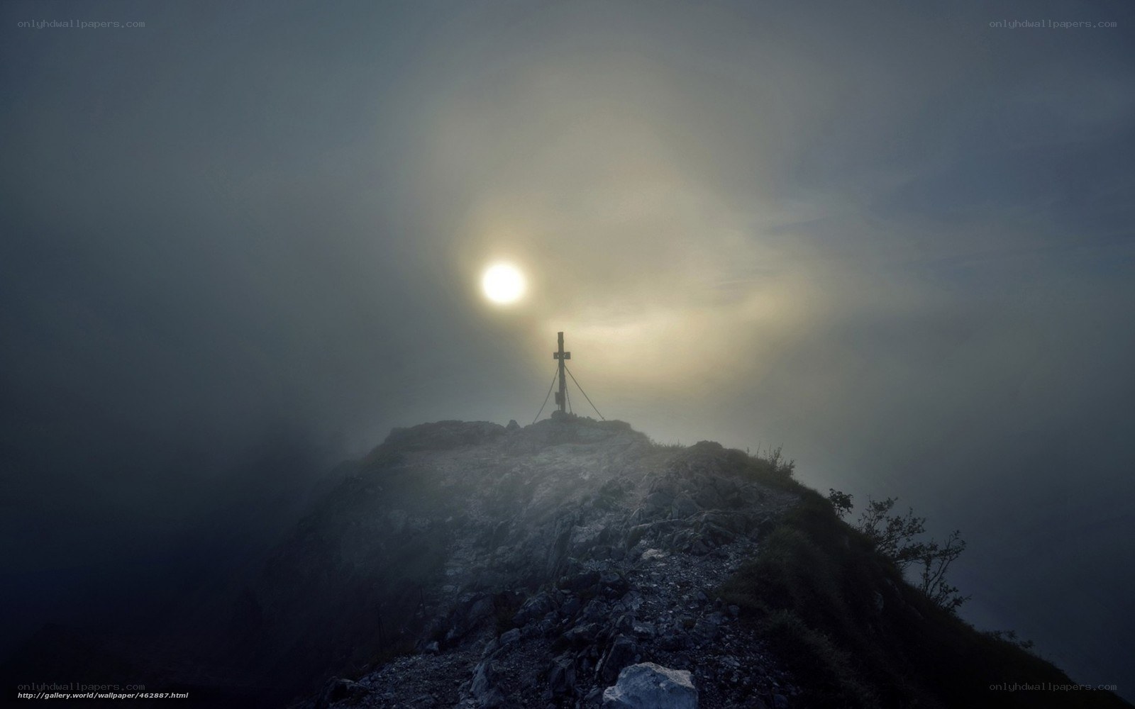 Mountain peak with cross at sunrise