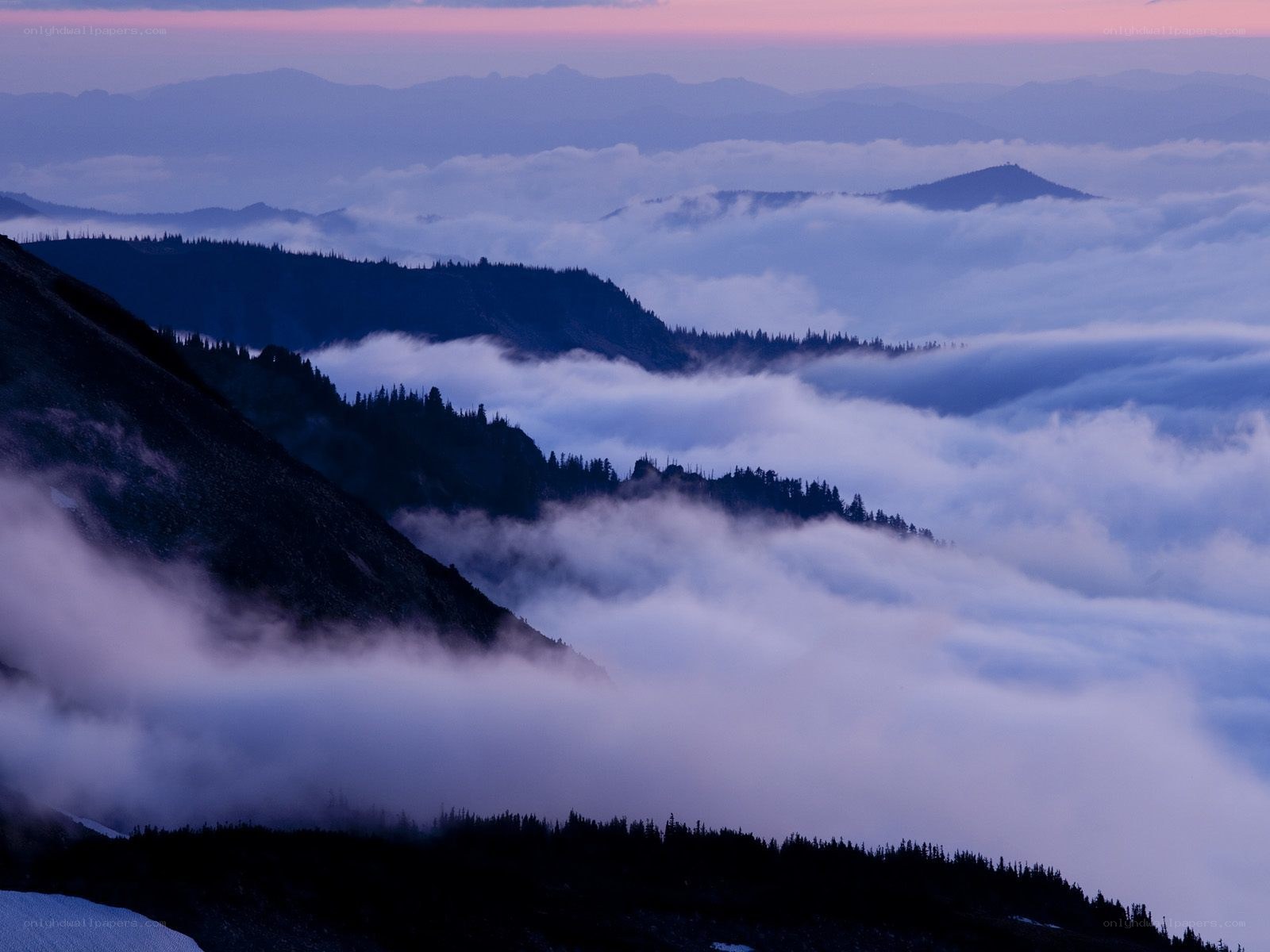Mountain peaks above clouds at dawn