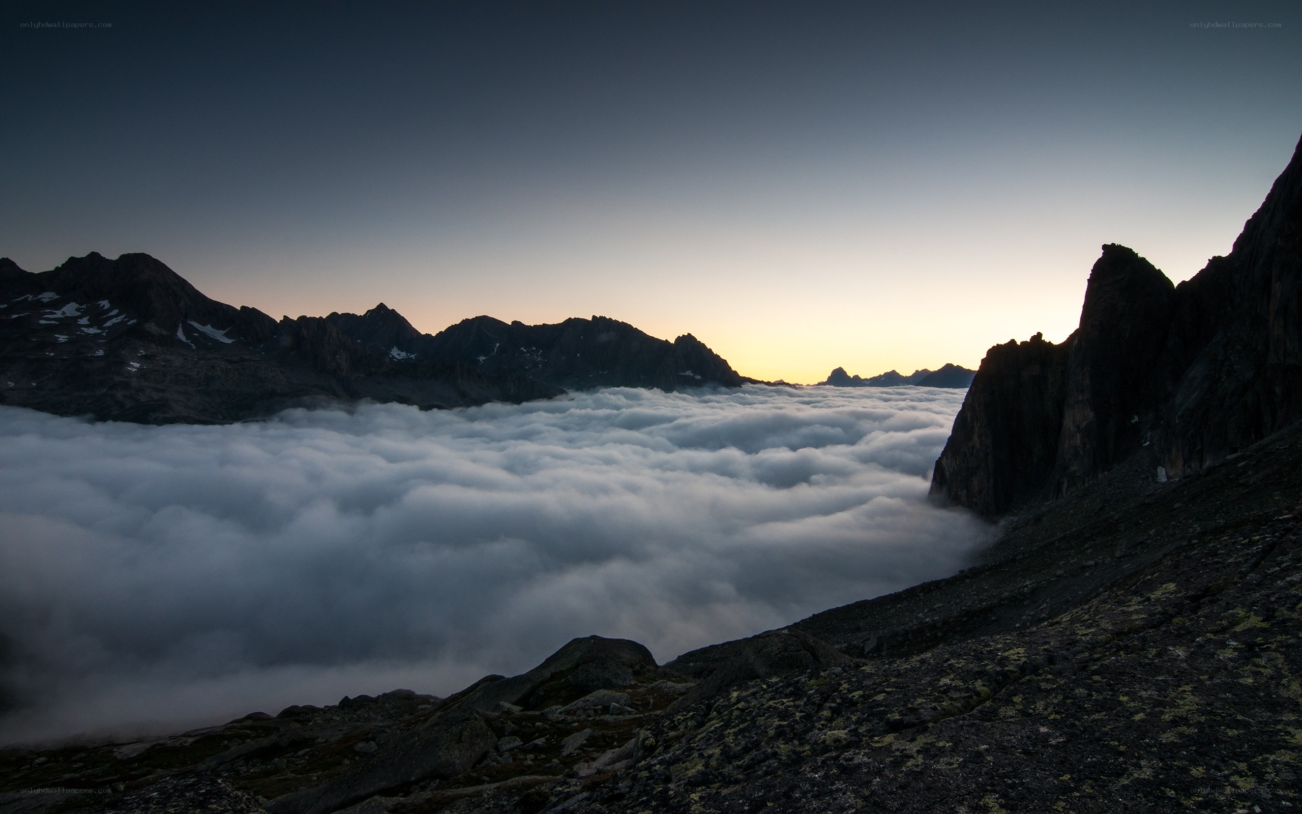 Mountain peaks above clouds at dawn