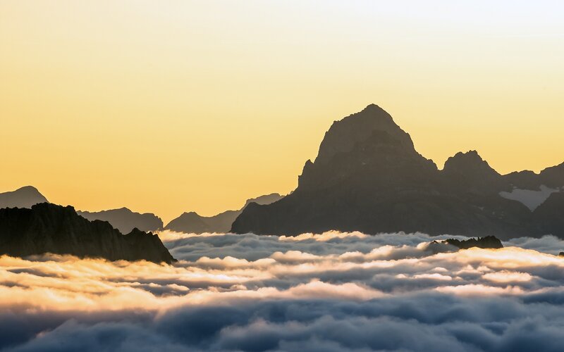 Mountain peaks above clouds at sunrise