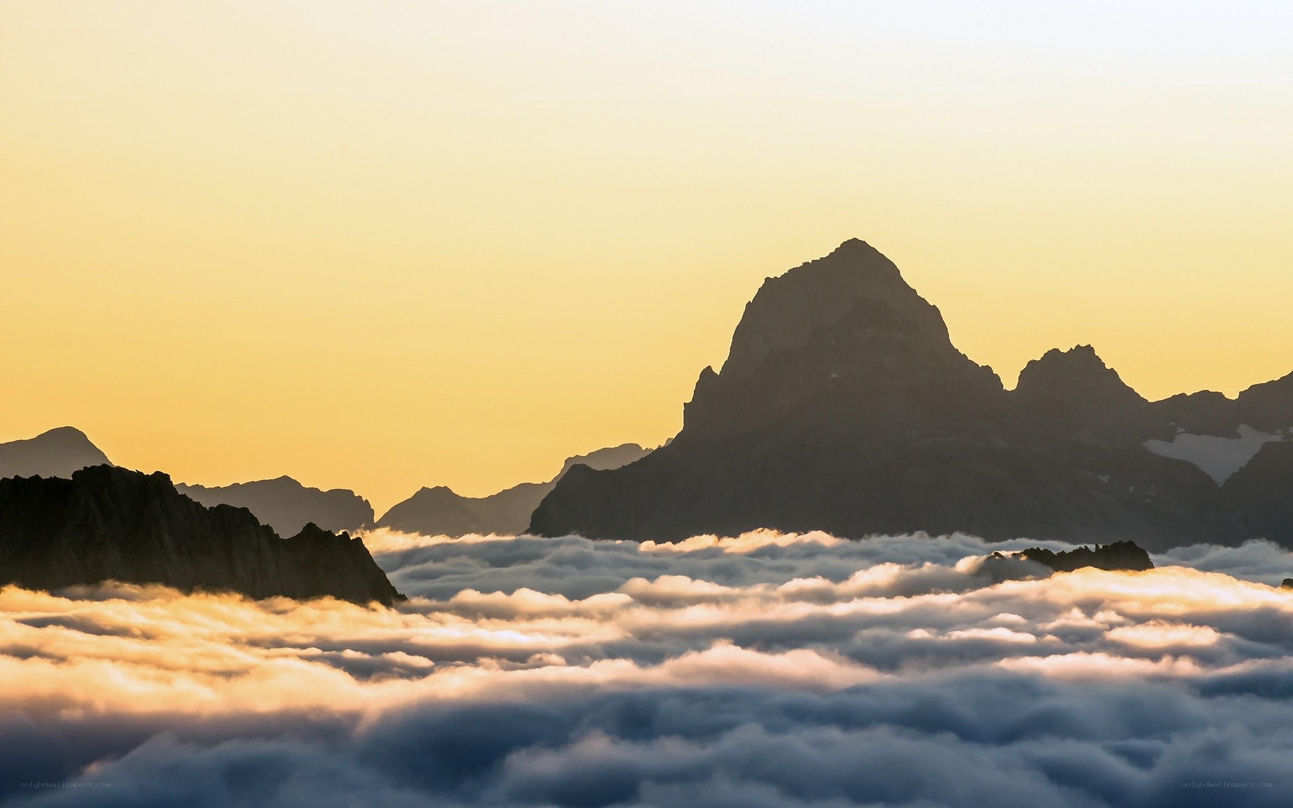Mountain peaks above clouds at sunrise