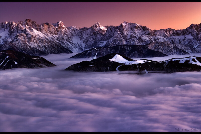 Mountain peaks above clouds at sunset