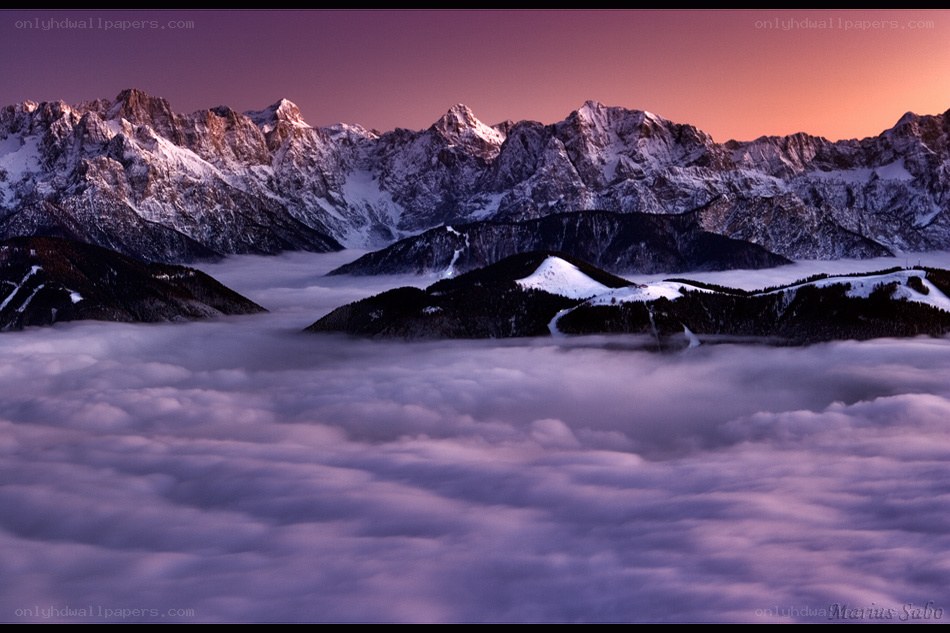 Mountain peaks above clouds at sunset