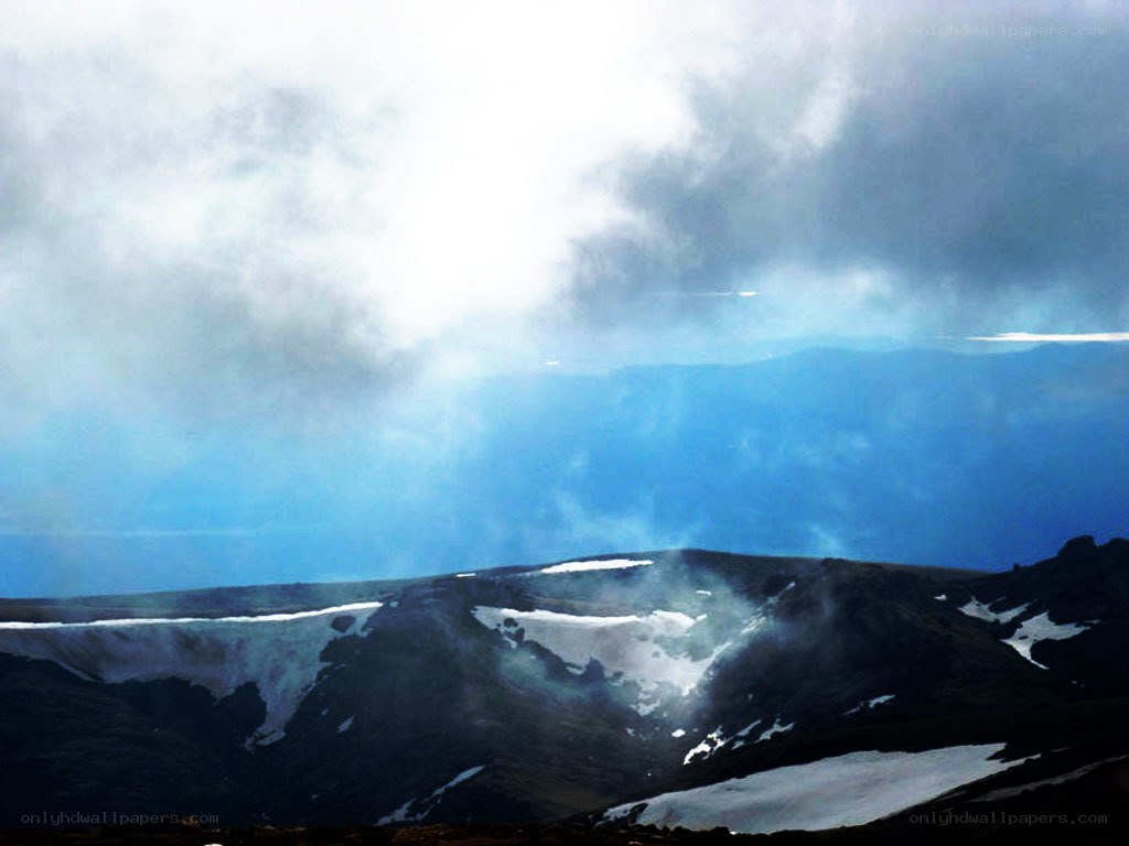 mountain peaks under cloudy sky