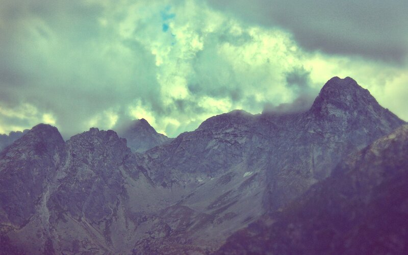 mountain peaks under cloudy sky