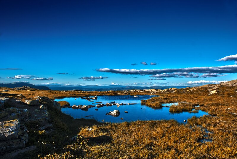 Mountain pond under blue sky