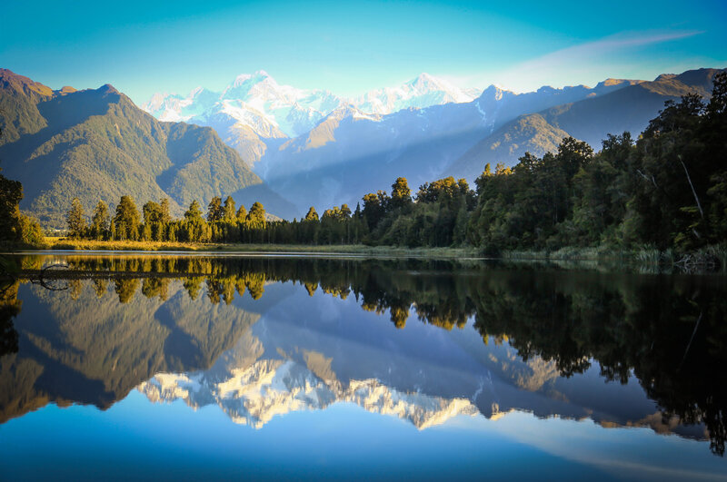 Mountain Range Reflection — Blue, Serene, Morning, Photograph, Lake, Trees, Snow-capped Peaks