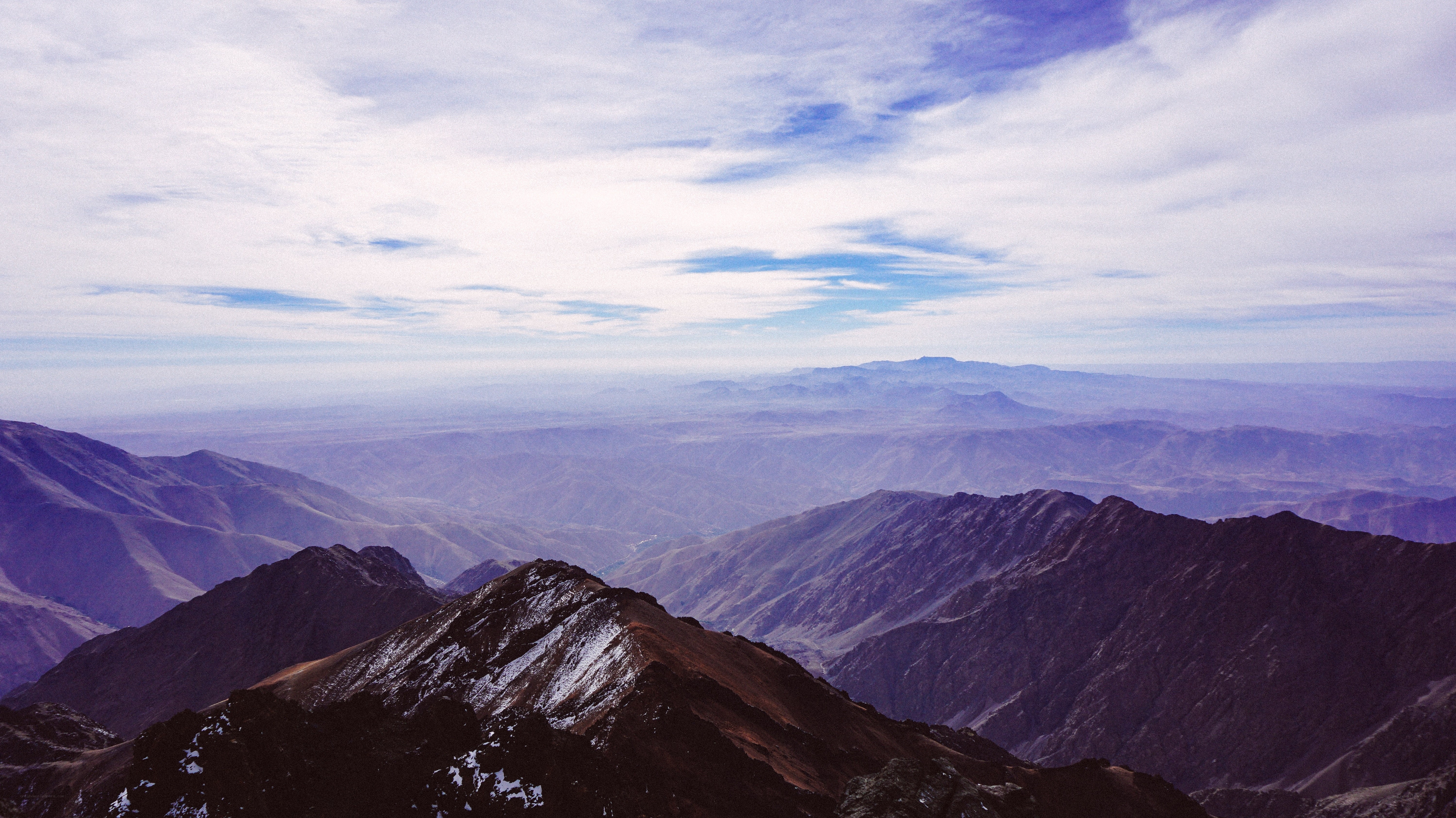 mountain range under cloudy sky