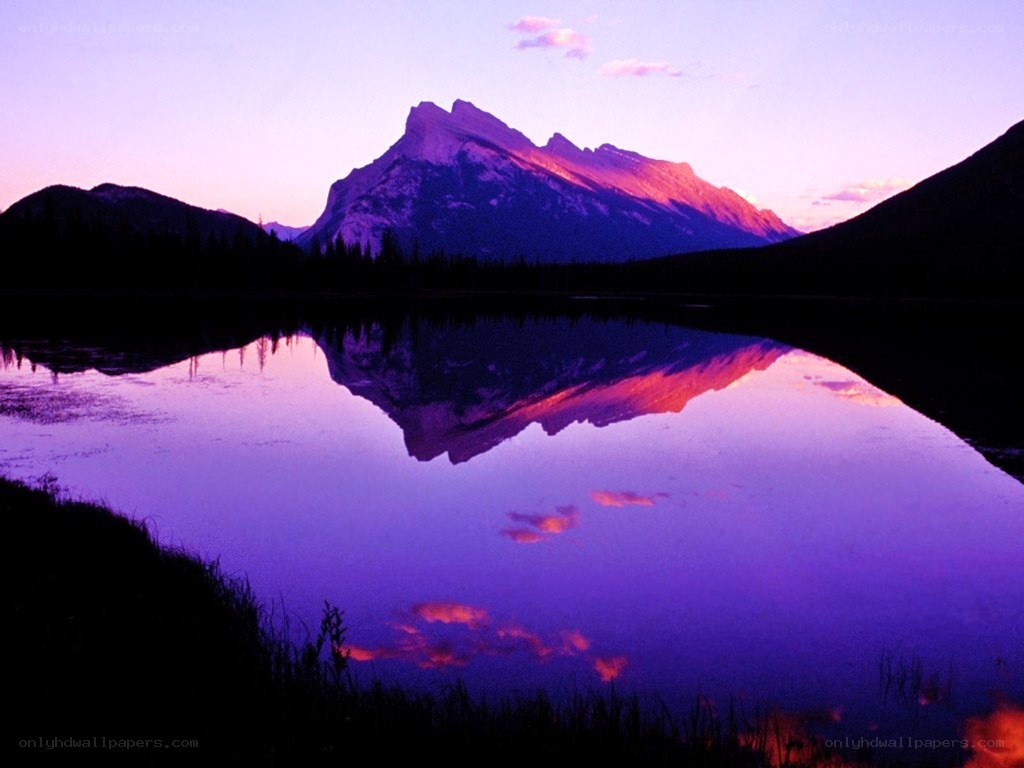 mountain reflected in lake at sunset