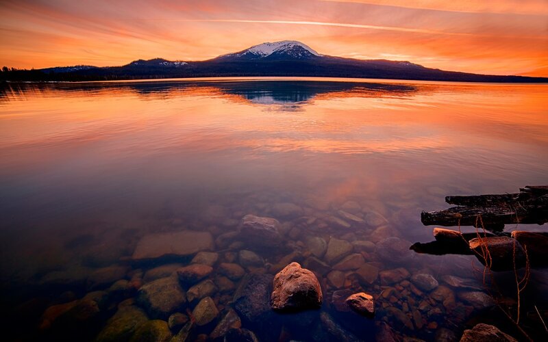 Mountain Reflected in Lake — Orange, Serene, Sunset, Photograph, Rocks, Snow-capped Mountain
