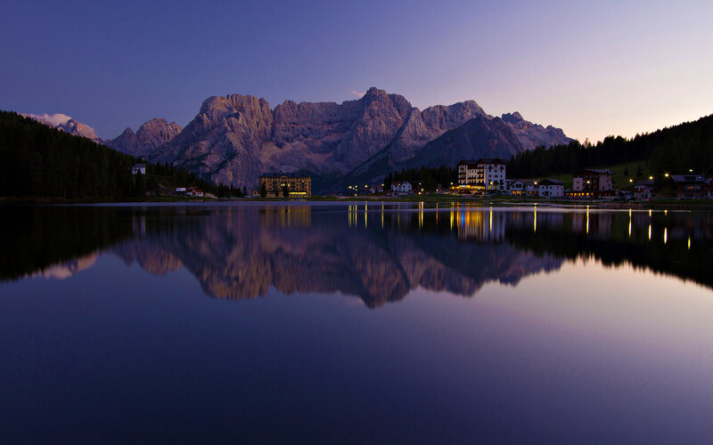 Mountain Reflection in Lake — Blue, Serene, Sunset, Photograph, Mountains, Buildings