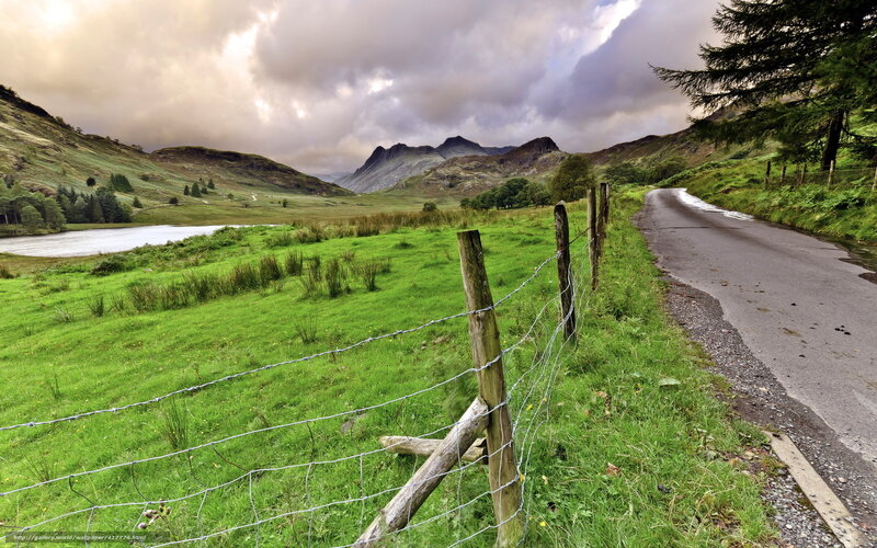 Mountain road with lake and fence