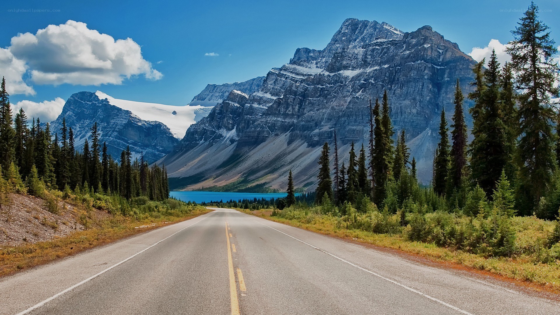 Mountain road with lake and peaks
