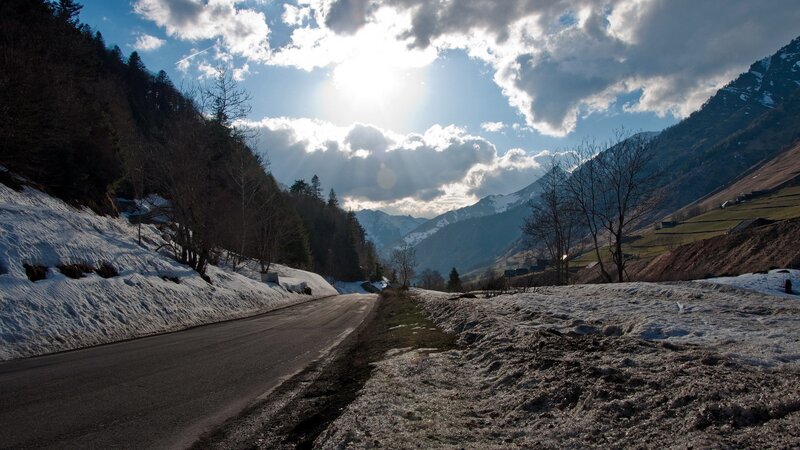 Mountain road with snow and sun