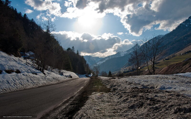Mountain road with snow and sun