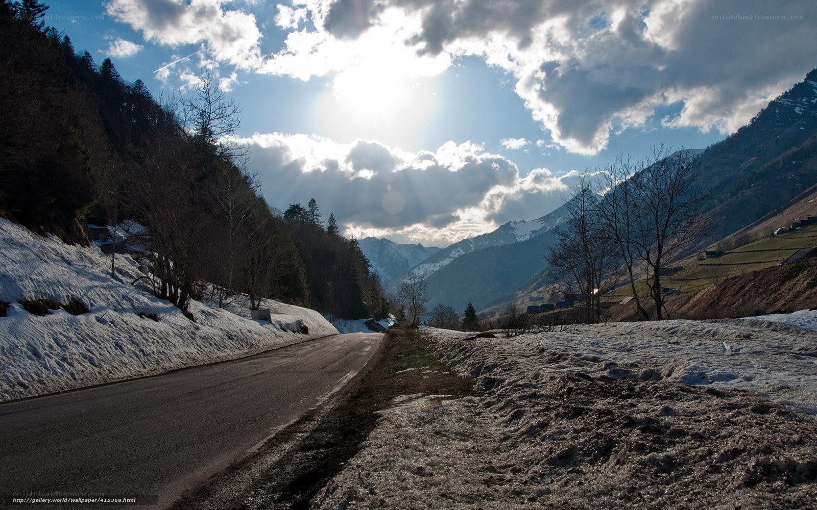 Mountain road with snow and sun
