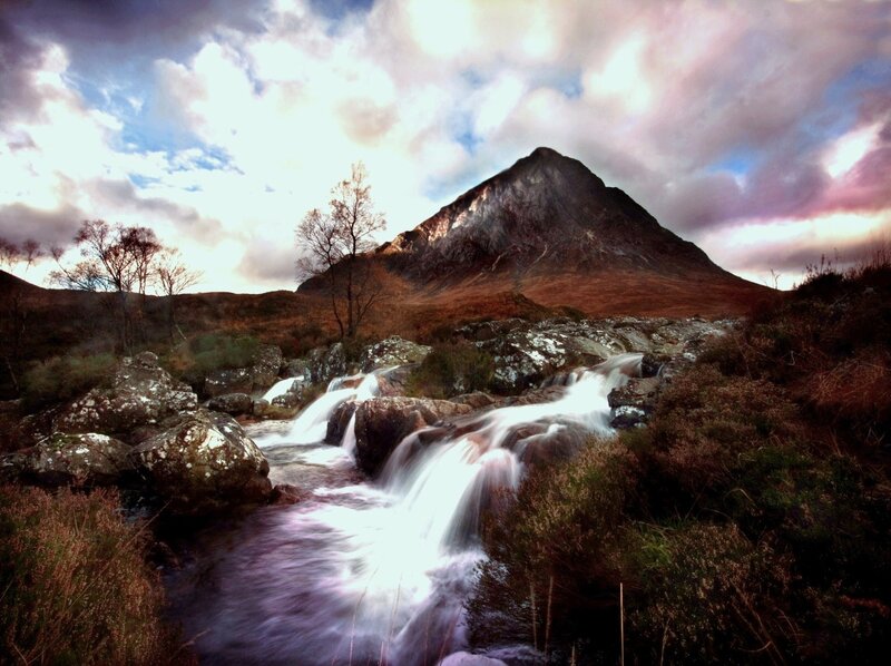 Mountain stream under cloudy sky
