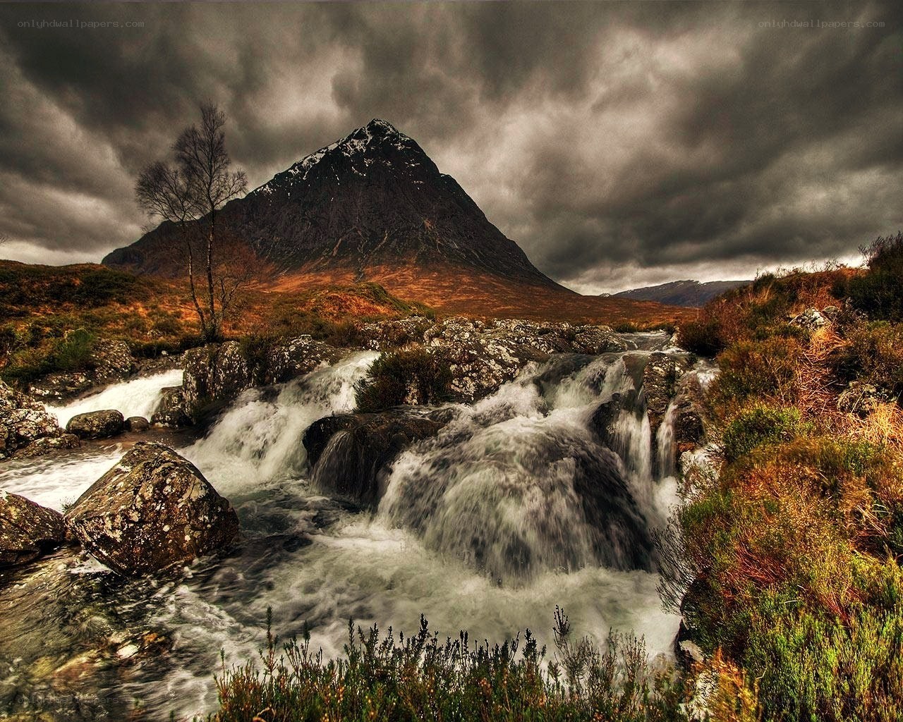 Mountain stream under stormy sky