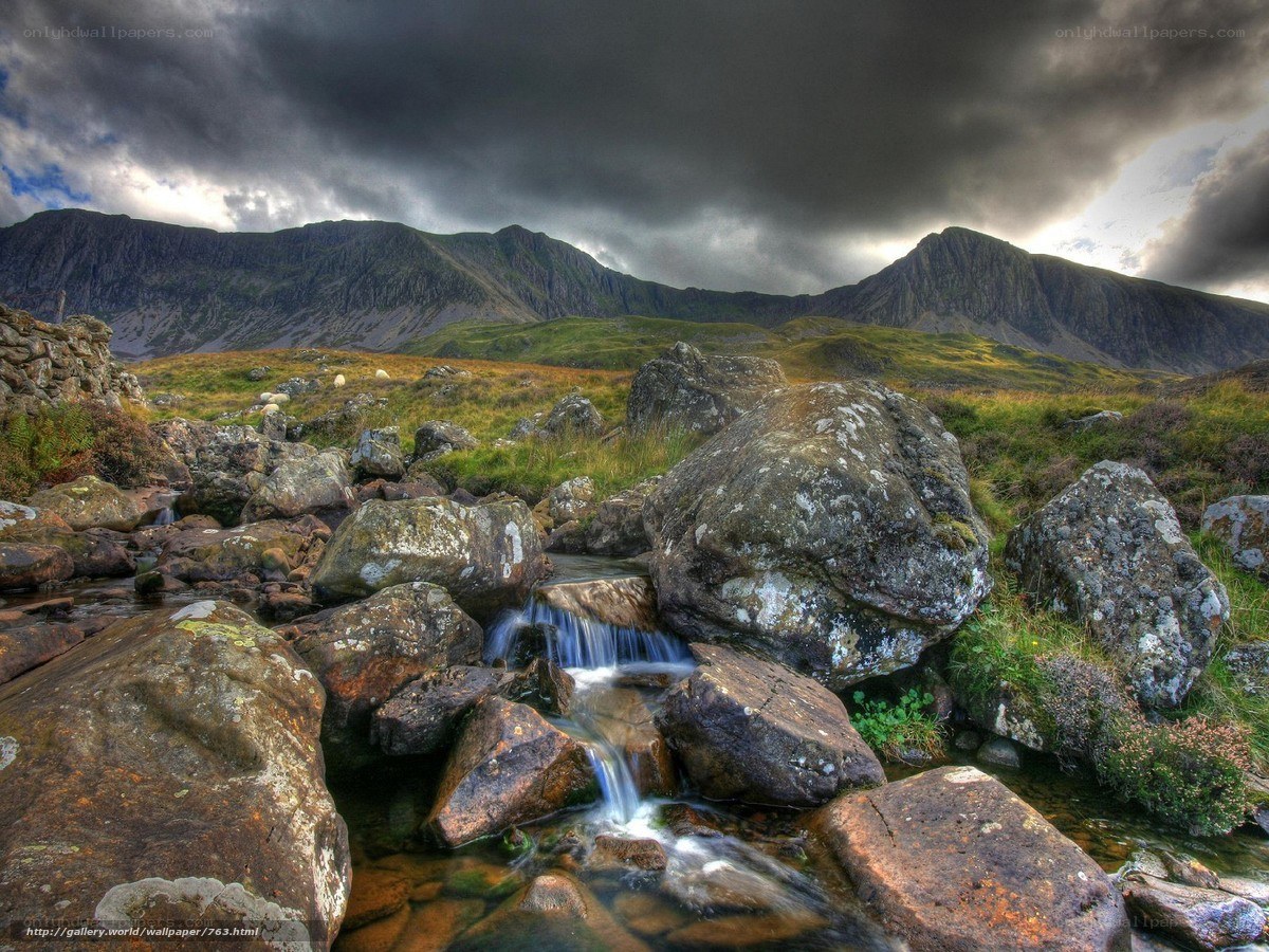 Mountain stream under stormy sky