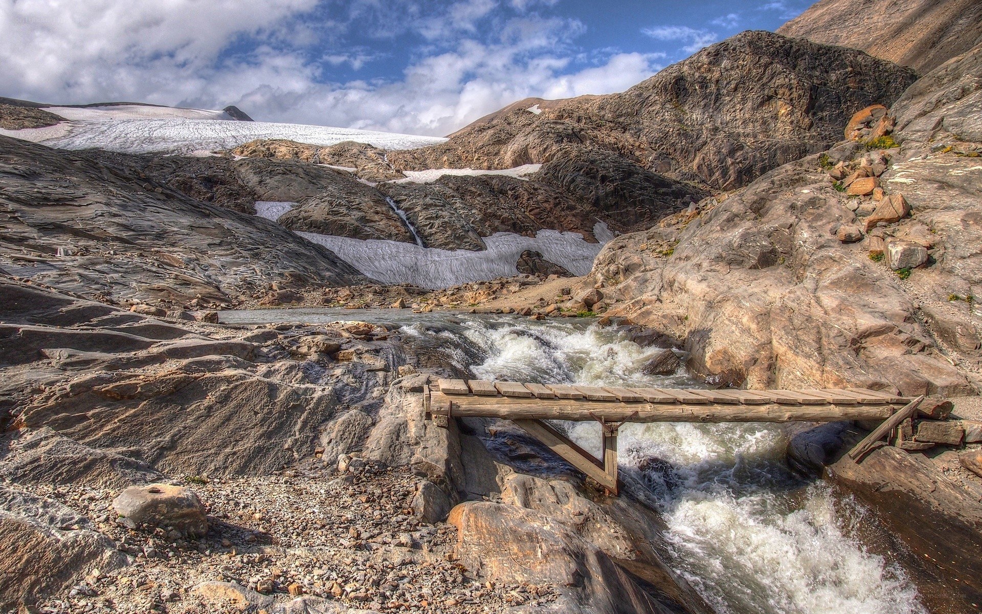 Mountain stream with wooden bridge