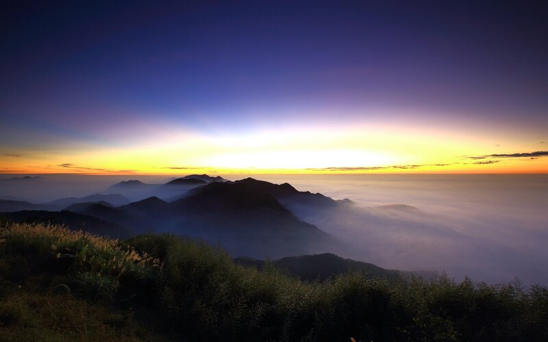 Mountain sunrise over sea of clouds