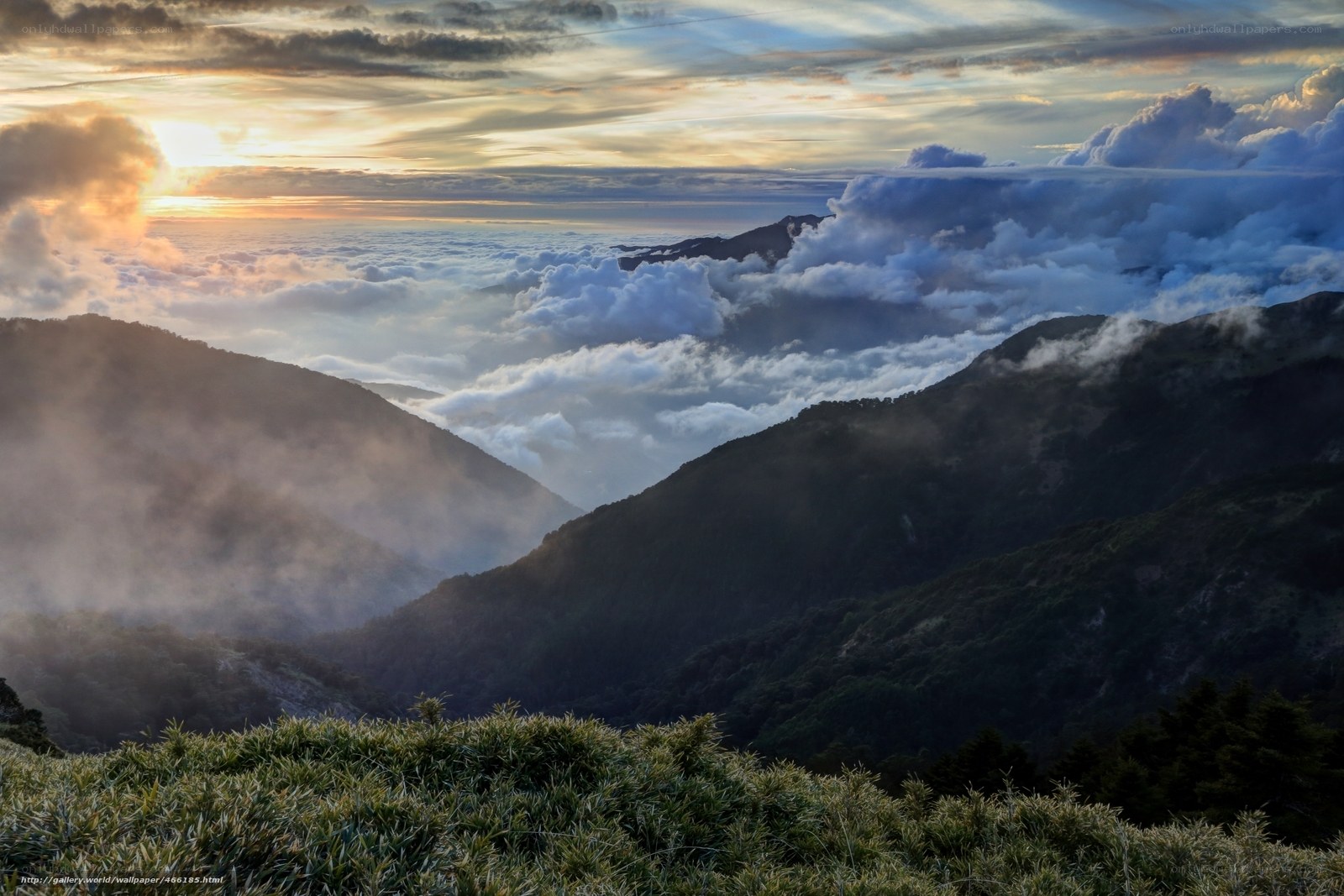 Mountain sunset above clouds
