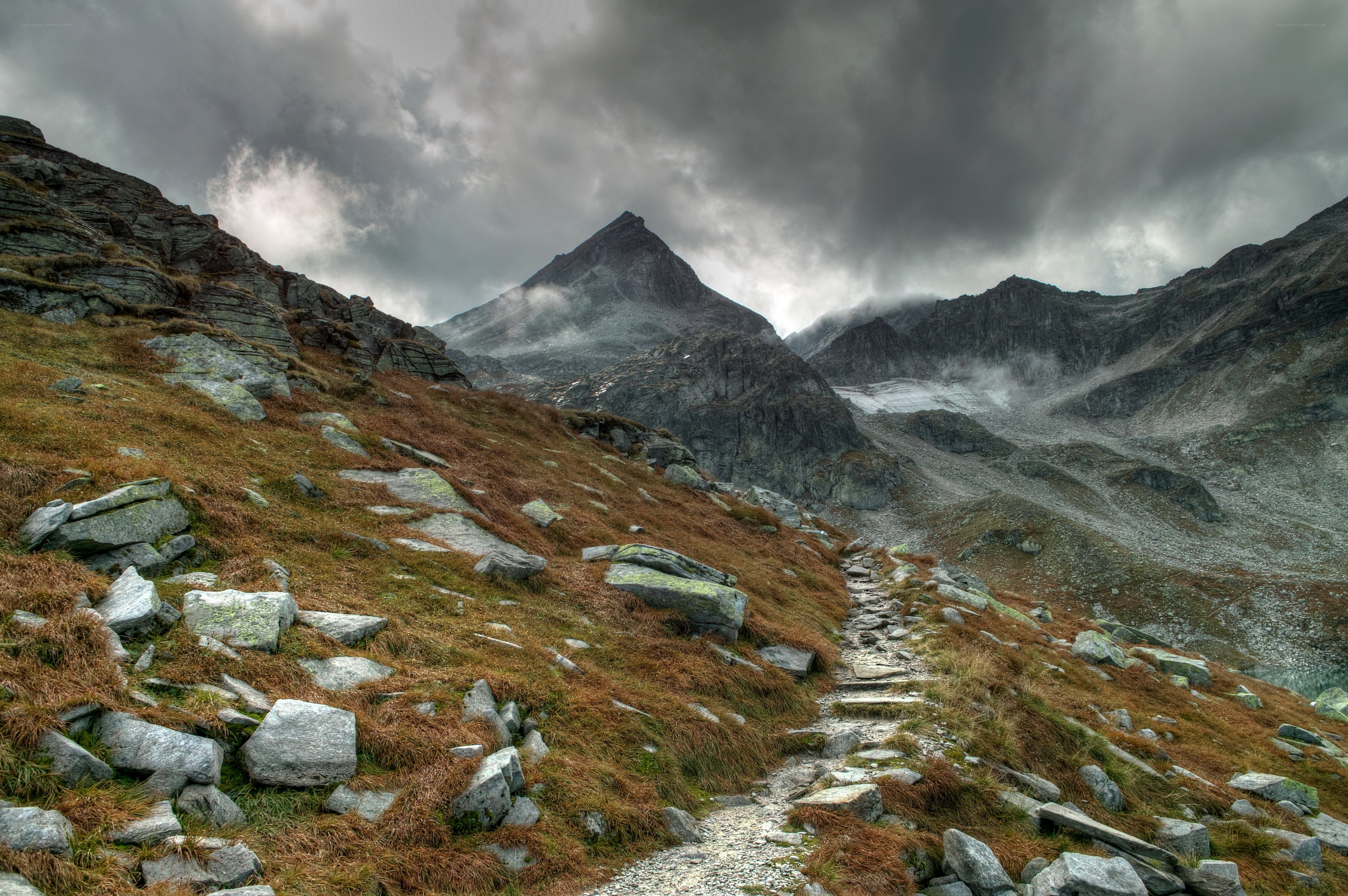 Mountain trail under stormy sky