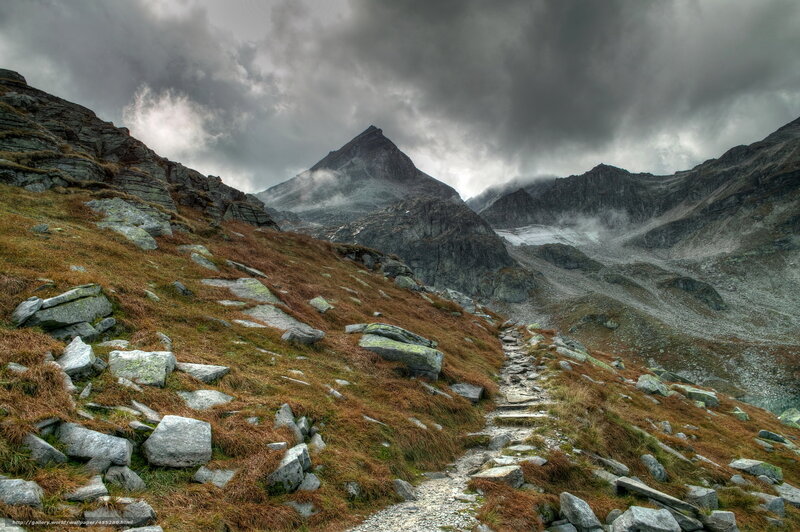 Mountain trail under stormy sky