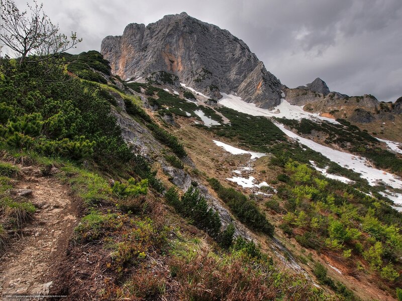 Mountain trail with snow patches