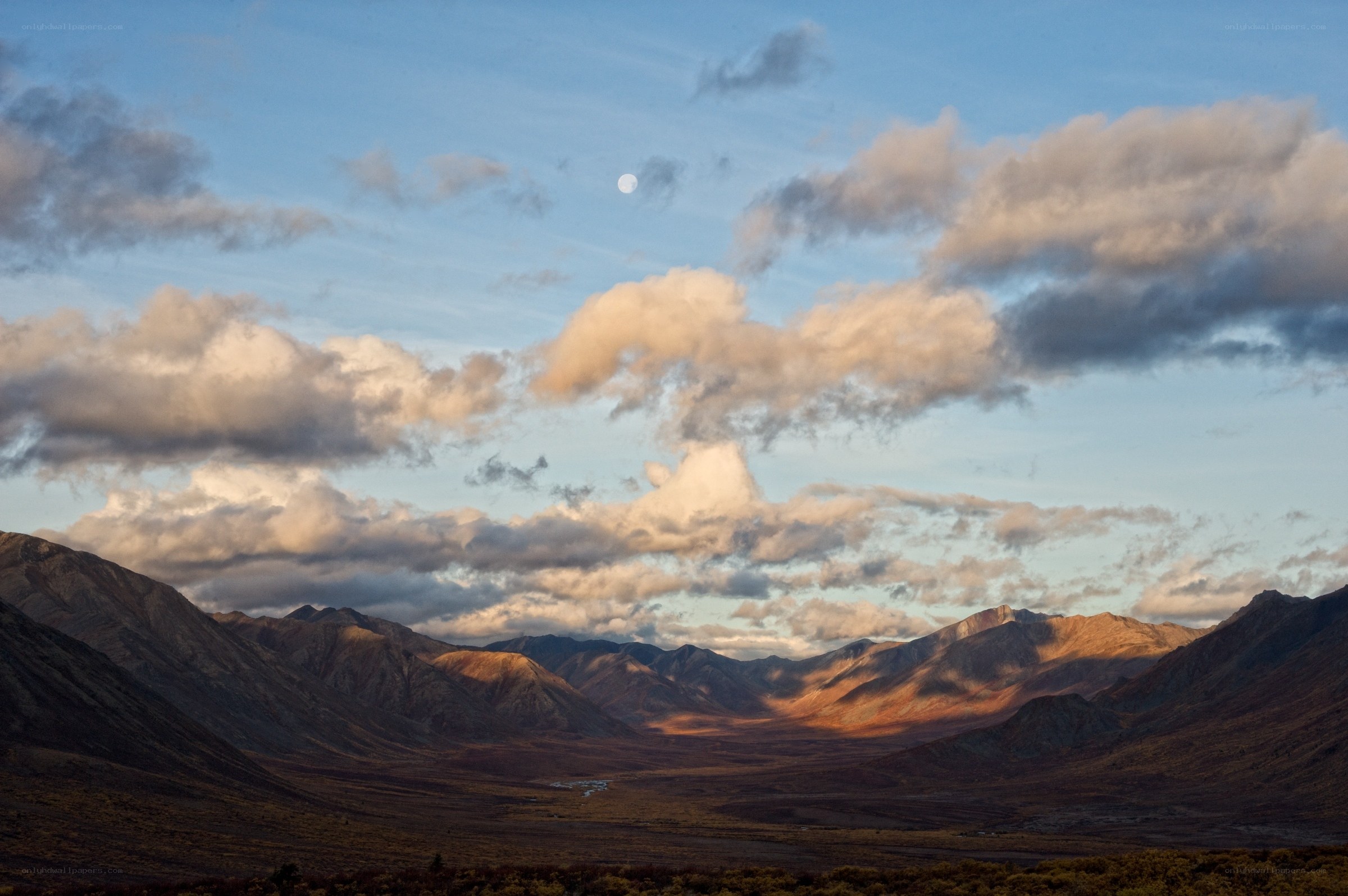Mountain valley at dusk with moon