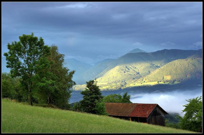 Mountain valley with barn and fog
