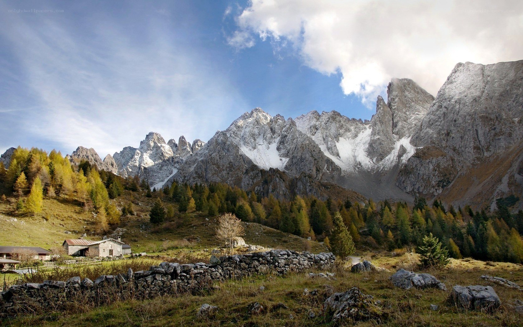 Mountain valley with cabin and peaks