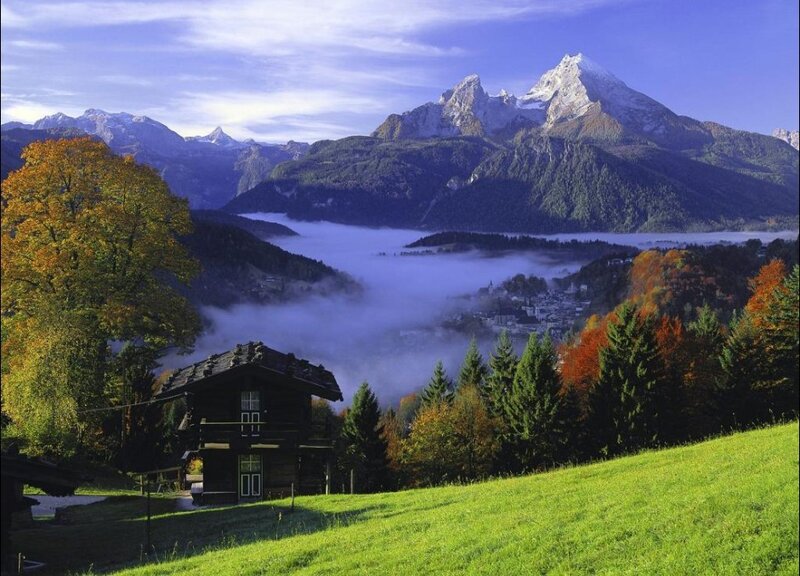 Mountain valley with fog and cabin