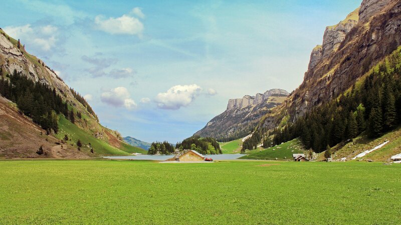 Mountain valley with lake and cabin
