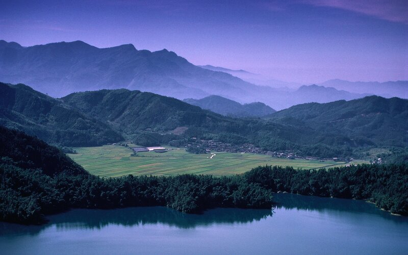 Mountain valley with lake and fields