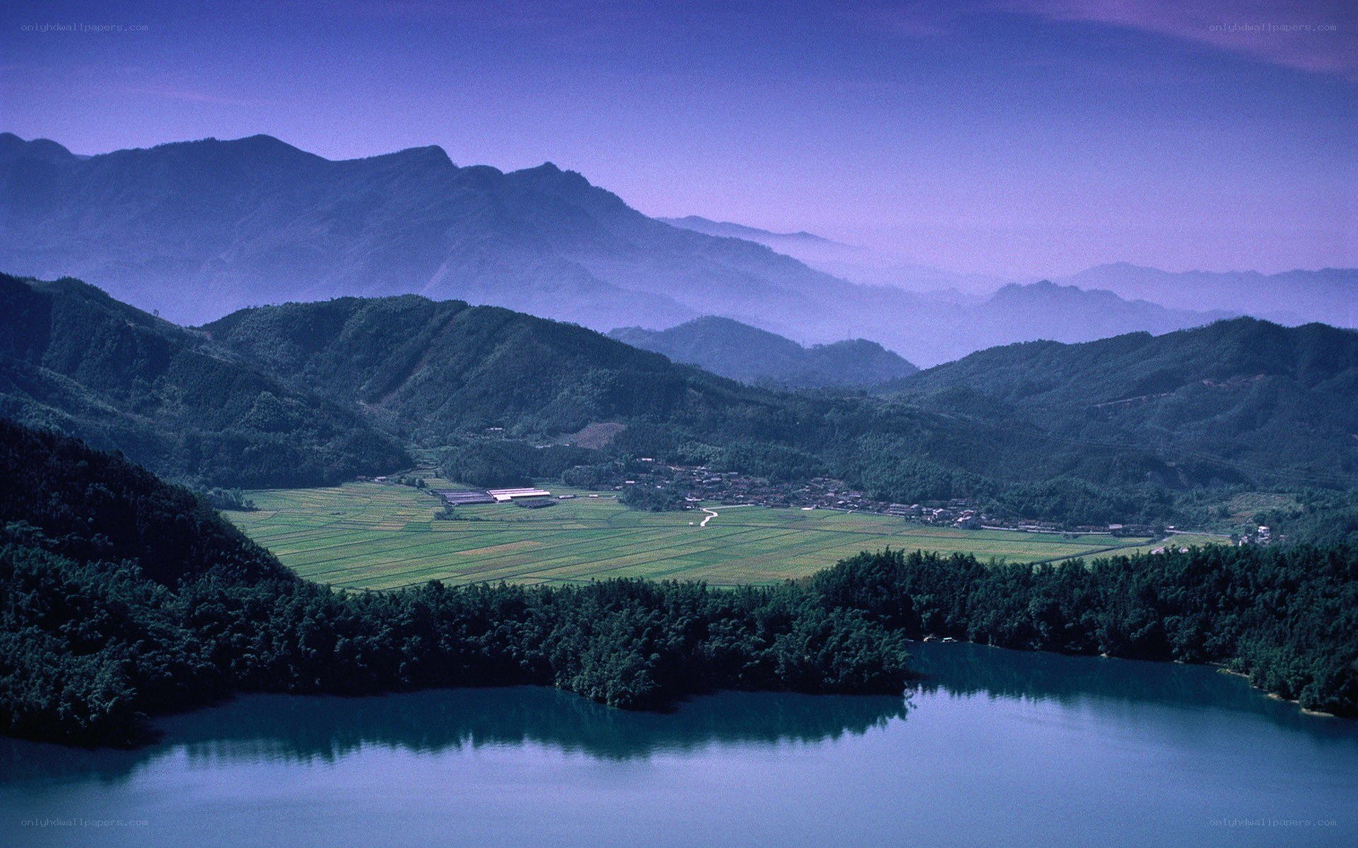 Mountain valley with lake and fields