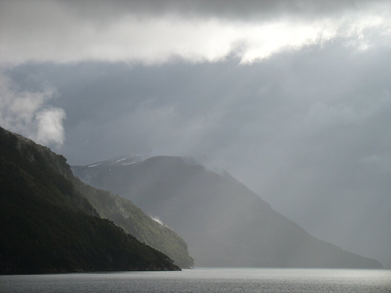 mountains and lake under cloudy sky