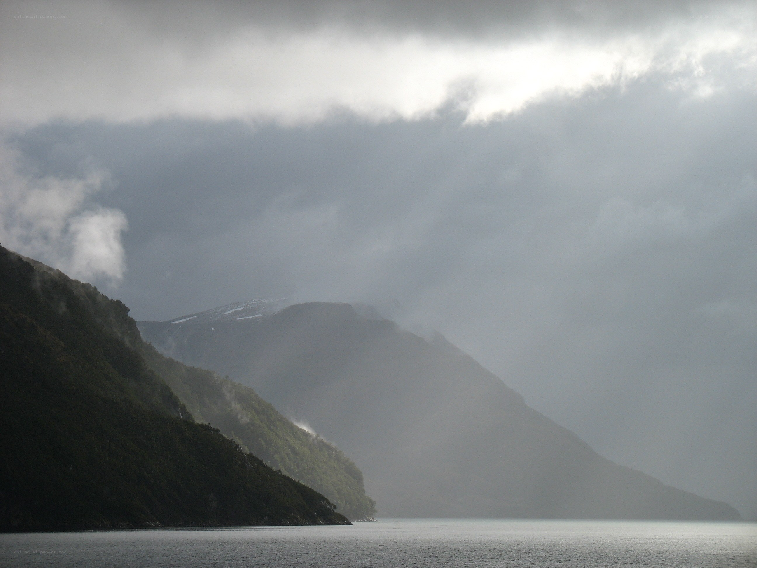 mountains and lake under cloudy sky
