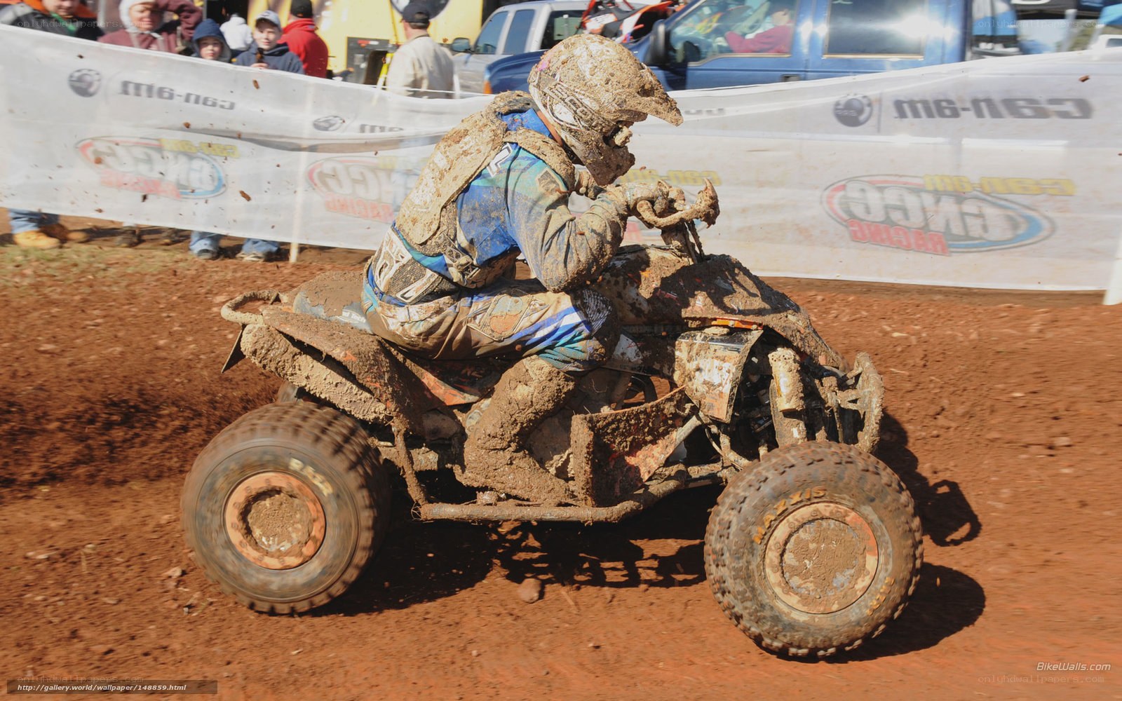 Mud-covered ATV racer in action