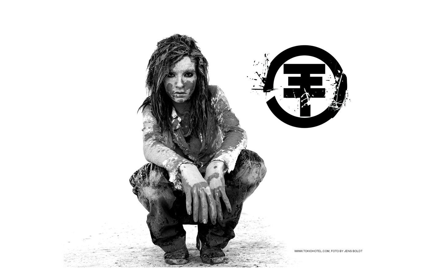 mud-covered person squatting