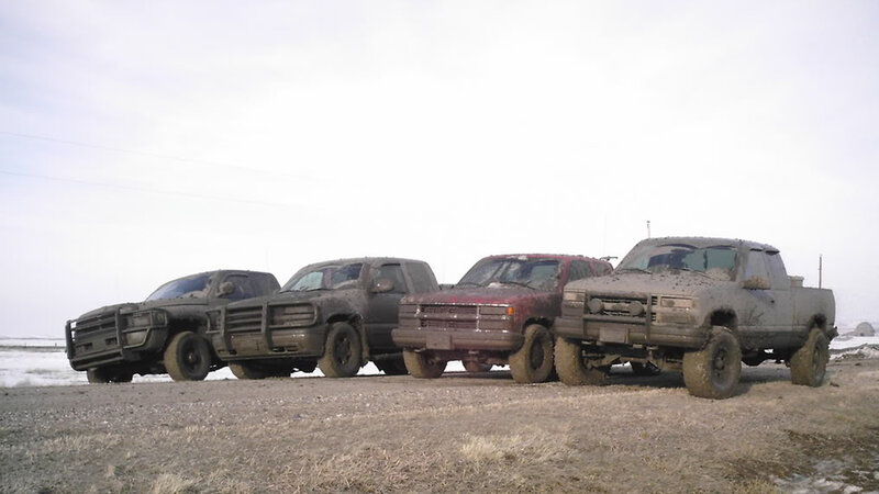 muddy trucks in a row
