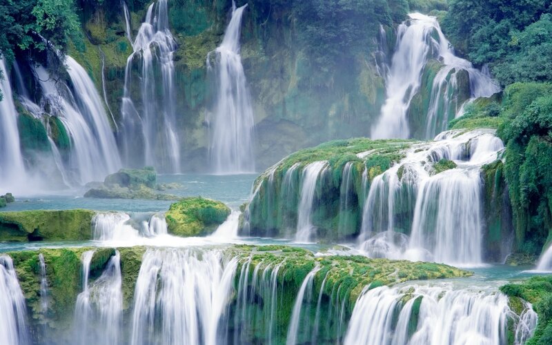 Multiple waterfalls in a lush forest