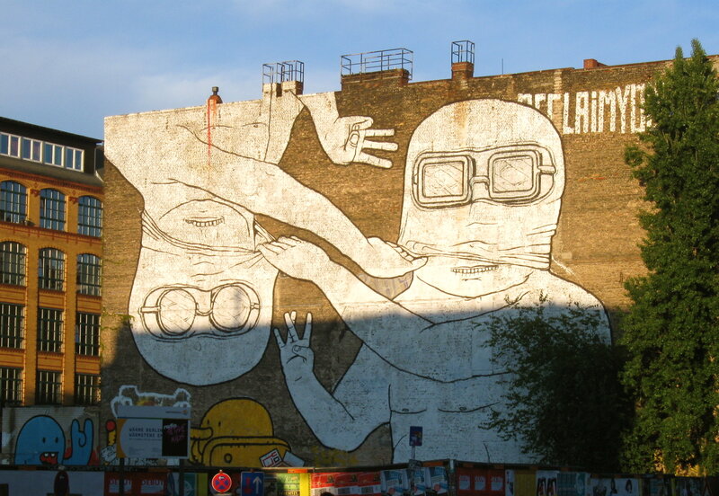 Mural of two figures on a brick wall