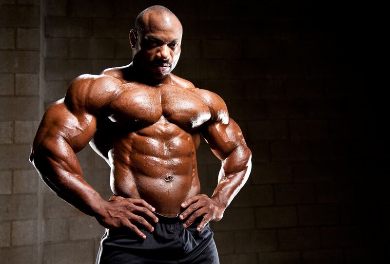 Muscular Man Posing — Brown, Dramatic, Photograph, Brick Wall