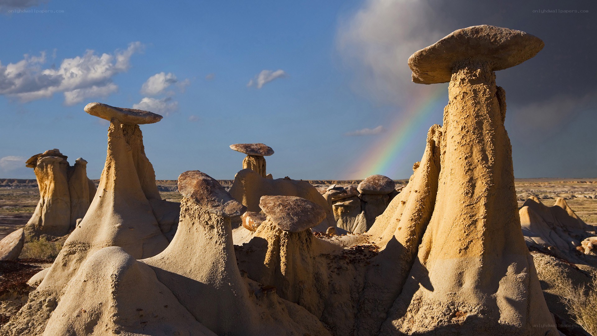 Mushroom rock formations with rainbow