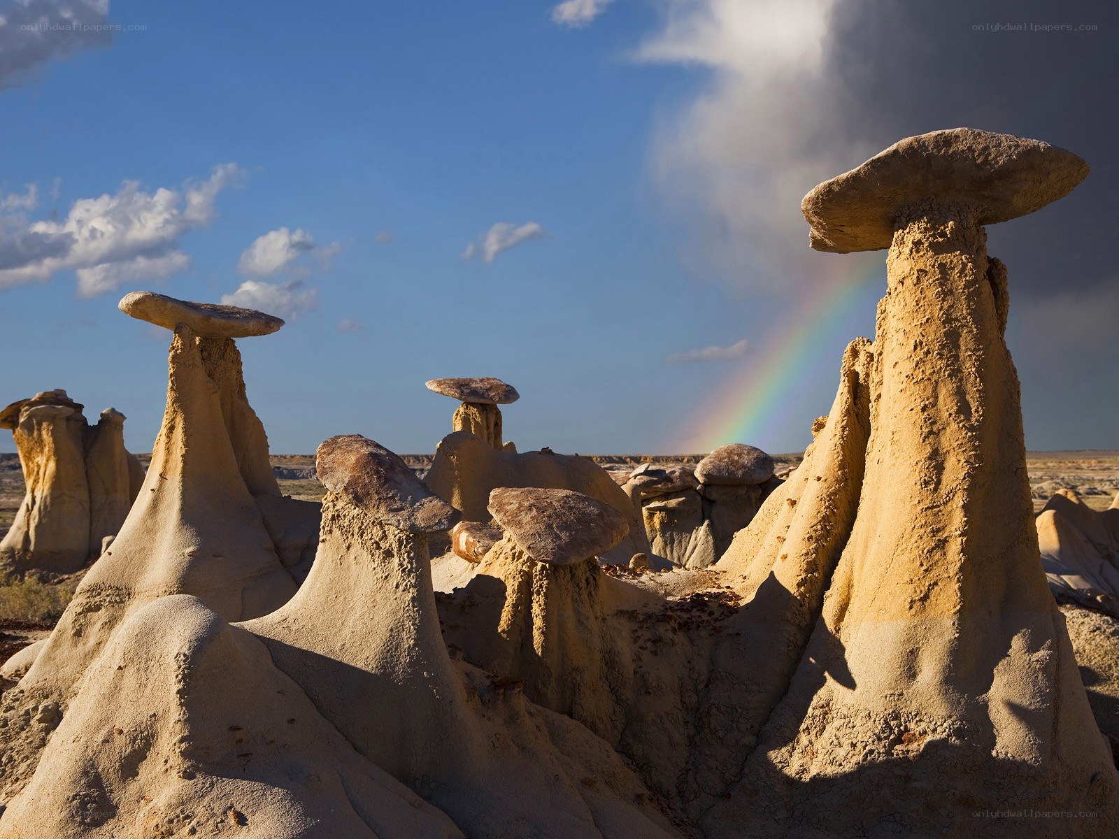 Mushroom rock formations with rainbow