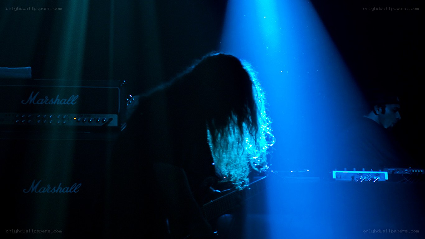 Musician on stage under blue light