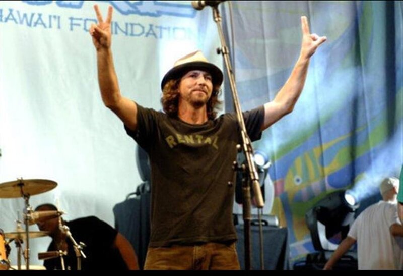 Musician on stage with hands raised